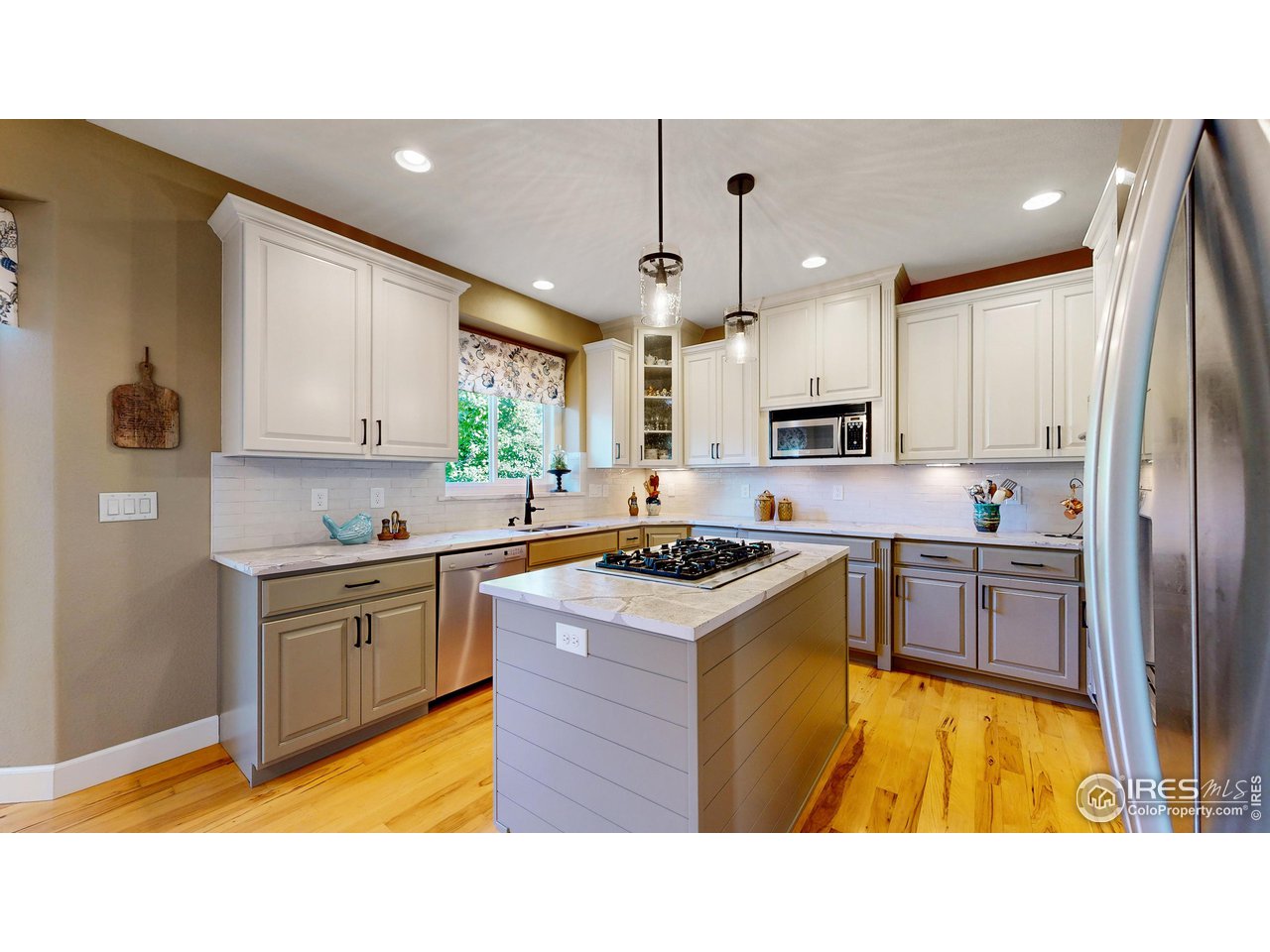 8398 Spinnaker Bay Drive Windsor, CO 80528 - Photo 9 of 40 a kitchen with stainless steel appliances granite countertop a stove refrigerator sink and cabinets