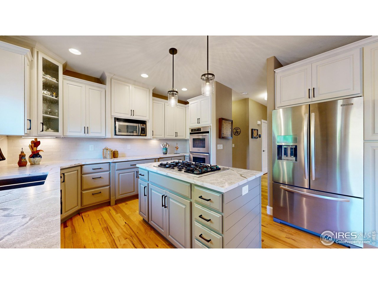 8398 Spinnaker Bay Drive Windsor, CO 80528 - Photo 10 of 40 a kitchen with kitchen island a counter top space a sink stainless steel appliances and cabinets