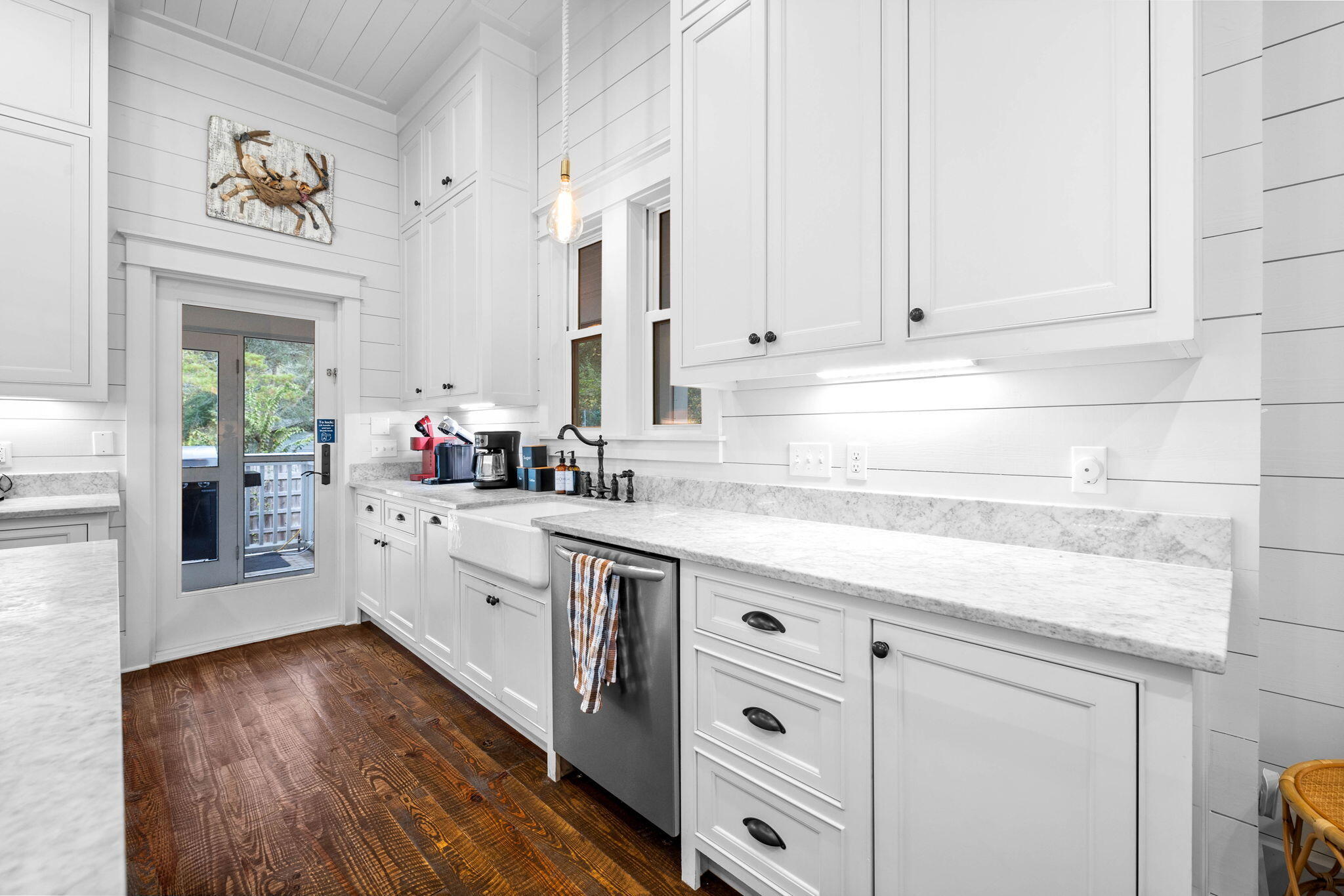 213 Bramble Street Santa Rosa Beach, FL 32459 - Photo 25 of 62 a kitchen with stainless steel appliances white cabinets and wooden floors