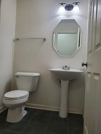 a bathroom with a toilet sink and mirror