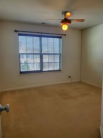 an empty room with a window and a ceiling fan