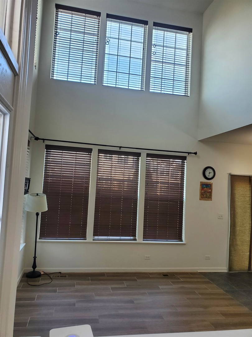 10070 Cummings Street, Unit 3401 Huntley, IL 60142 - Photo 5 of 27 a view of an empty room with wooden floor and a window