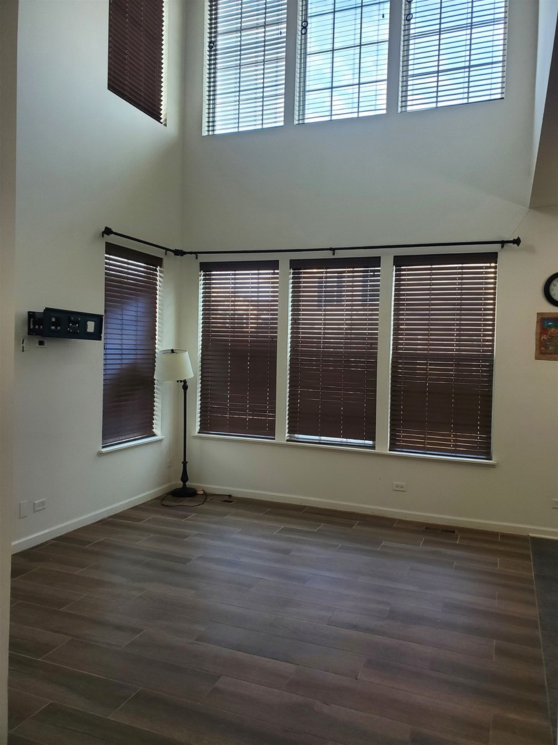 10070 Cummings Street, Unit 3401 Huntley, IL 60142 - Photo 6 of 27 a view of an empty room with wooden floor and a window