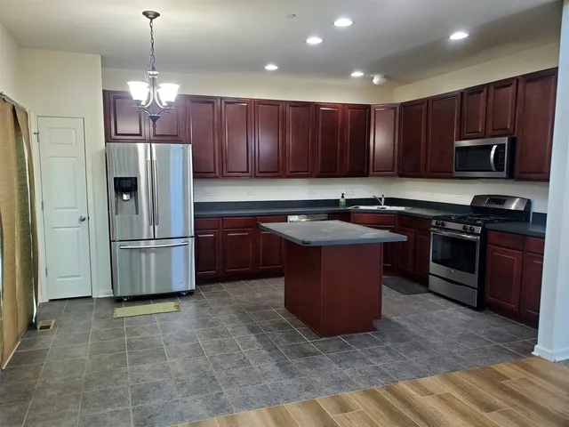 a kitchen with stainless steel appliances granite countertop a stove a sink dishwasher a refrigerator and a microwave oven
