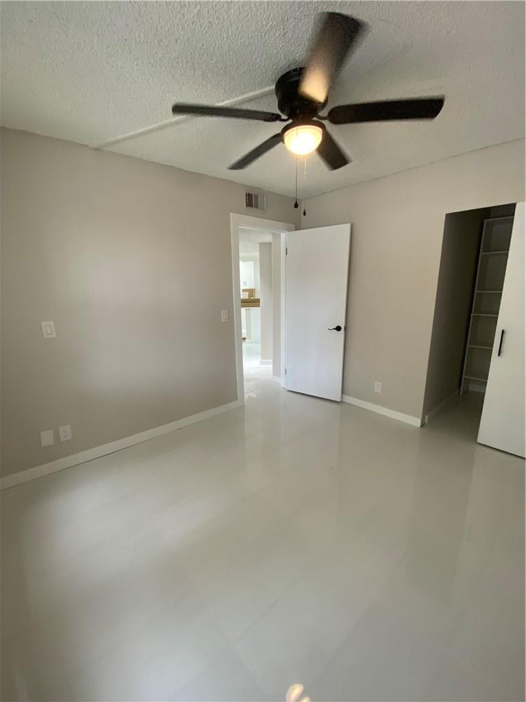 8801 Wiles Road, Unit 207 Coral Springs, FL 33067 - Photo 23 of 31 an empty room with a ceiling fan and a window