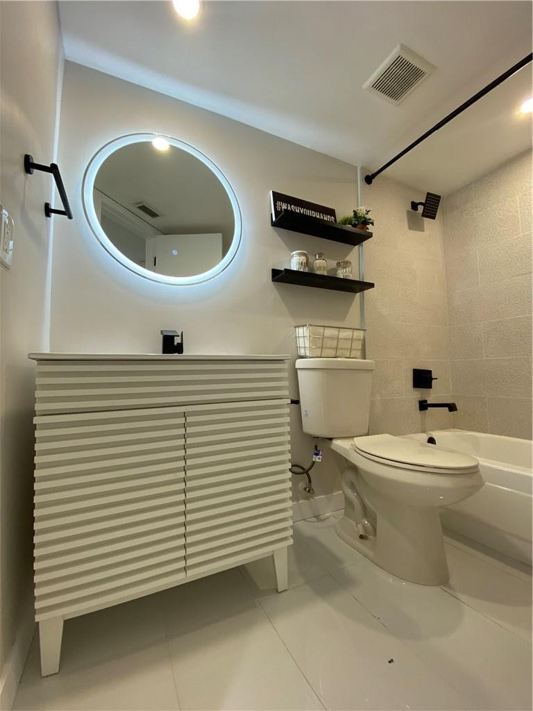 8801 Wiles Road, Unit 207 Coral Springs, FL 33067 - Photo 27 of 31 a bathroom with a sink a toilet and a mirror