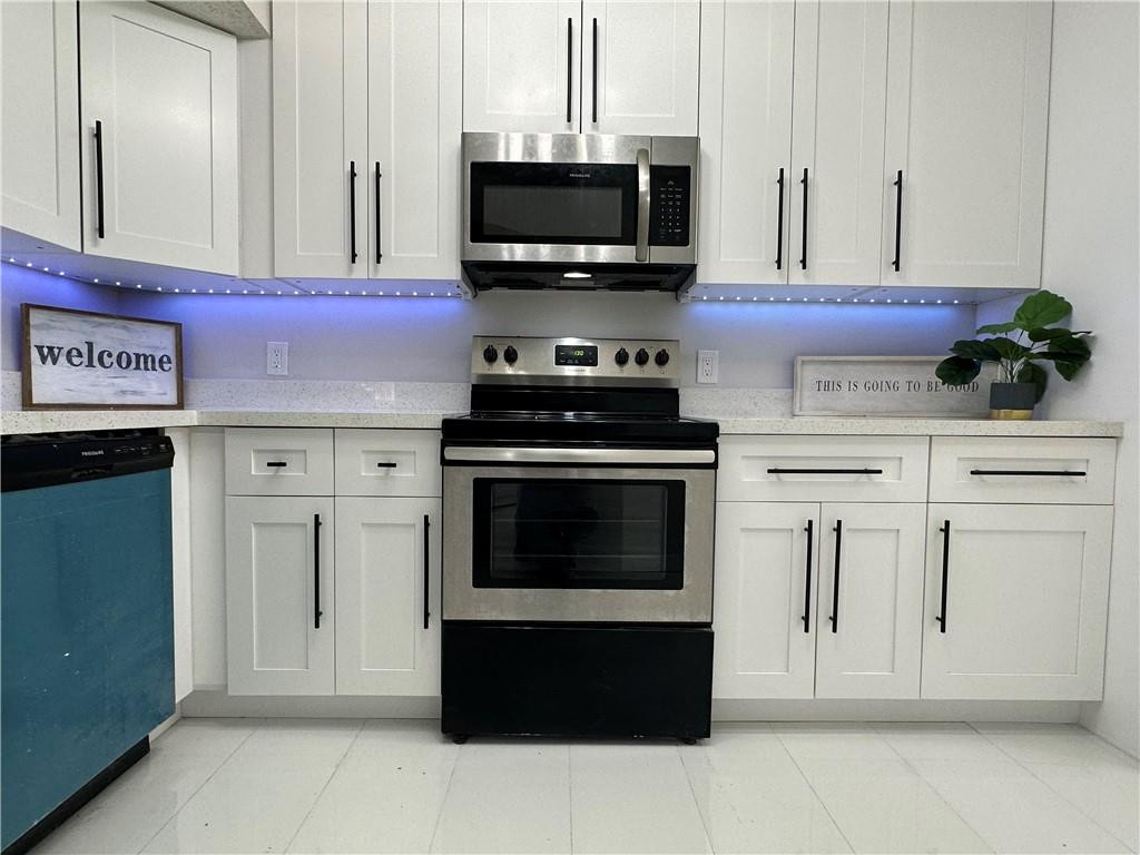 8801 Wiles Road, Unit 207 Coral Springs, FL 33067 - Photo 4 of 31 a kitchen with stainless steel appliances a stove top oven and cabinets