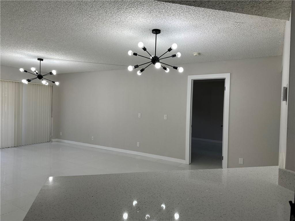 8801 Wiles Road, Unit 207 Coral Springs, FL 33067 - Photo 9 of 31 a view of an empty room with a chandelier fan