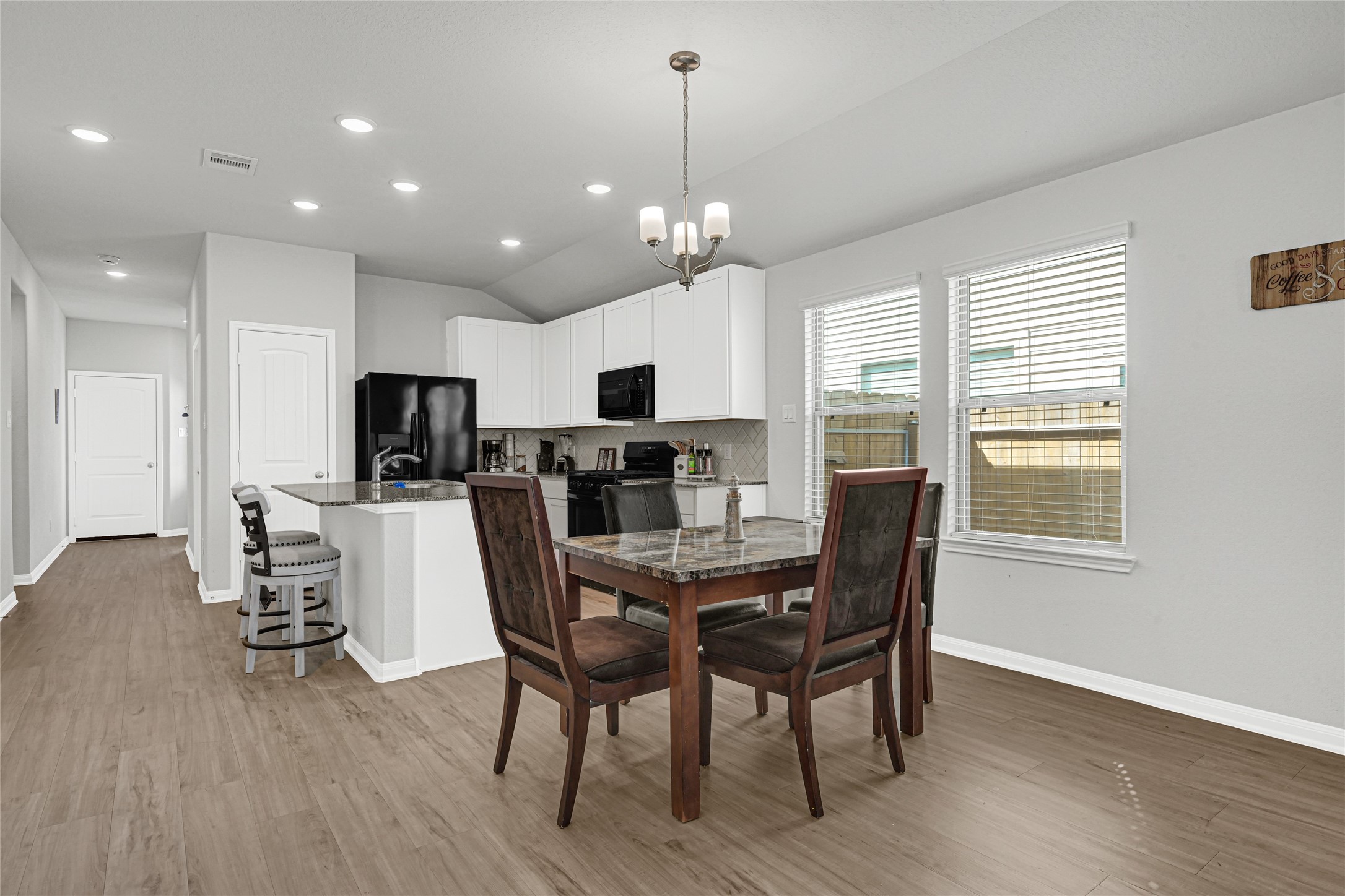 5325 Basquiat Drive Houston, TX 77048 - Photo 9 of 21 a view of a dining room with furniture a chandelier and wooden floor