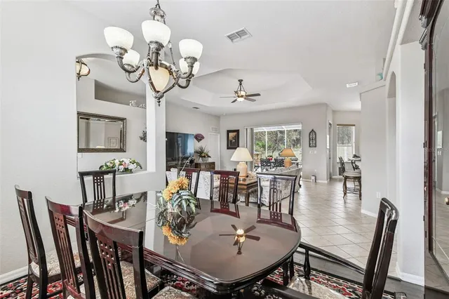 a view of a dining room with furniture a chandelier and wooden floor