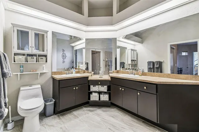 a spacious bathroom with a double vanity sink toilet and a mirror