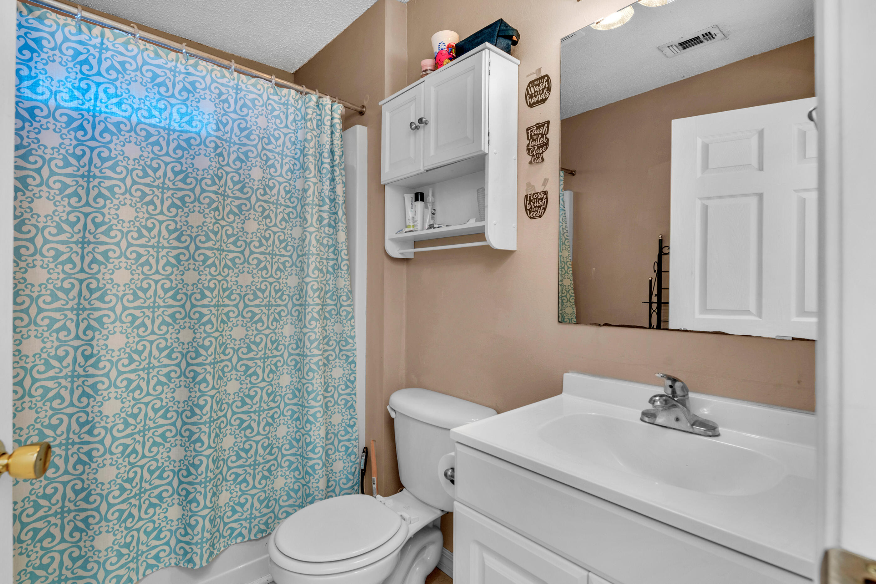 220 Riverchase Boulevard Crestview, FL 32536 - Photo 11 of 24 a bathroom with a sink a toilet and shower curtain