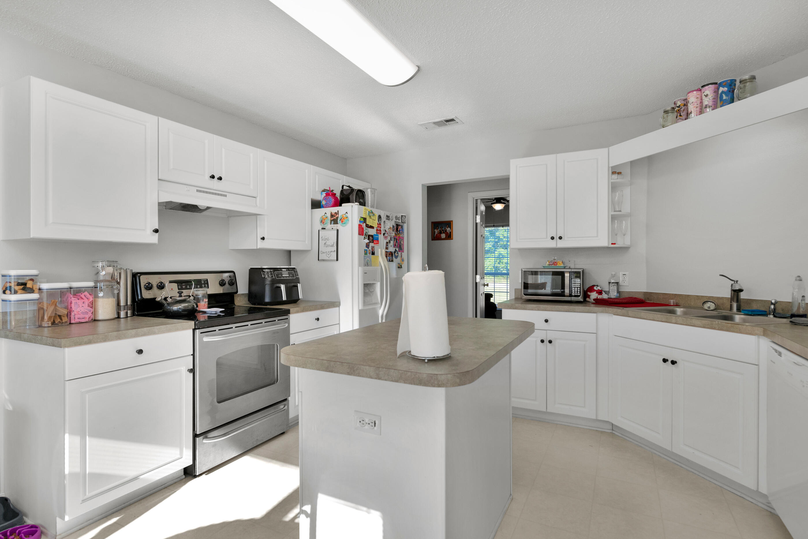 220 Riverchase Boulevard Crestview, FL 32536 - Photo 2 of 24 a kitchen with granite countertop white cabinets and white appliances