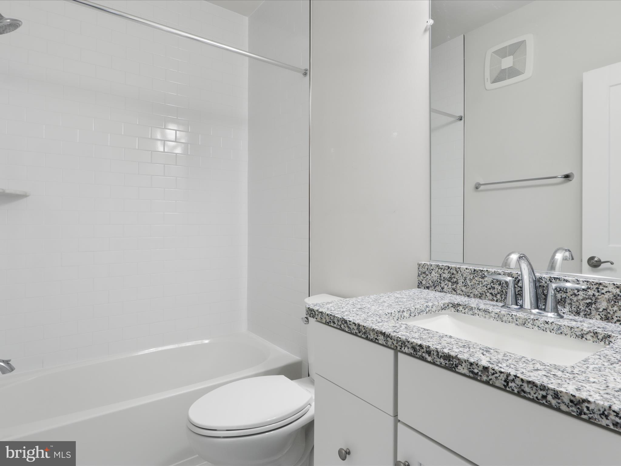 1696 Bandit Loop Reston, VA 20190 - Photo 23 of 38 a bathroom with a granite countertop sink toilet and shower