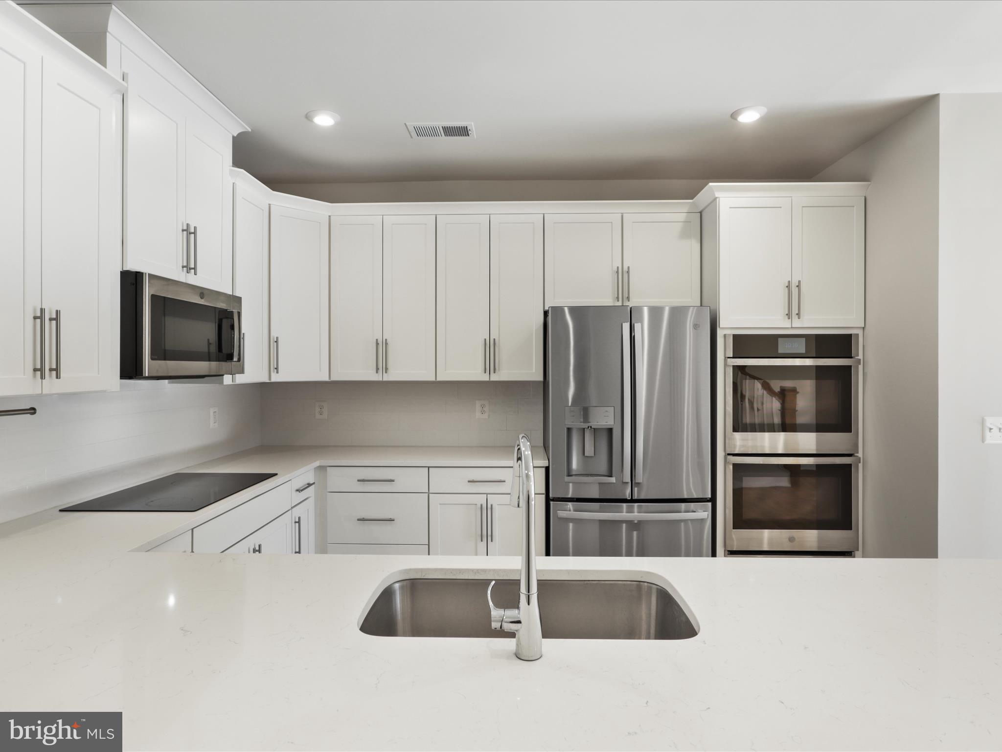 1696 Bandit Loop Reston, VA 20190 - Photo 8 of 38 a kitchen with stainless steel appliances granite countertop a refrigerator and a sink