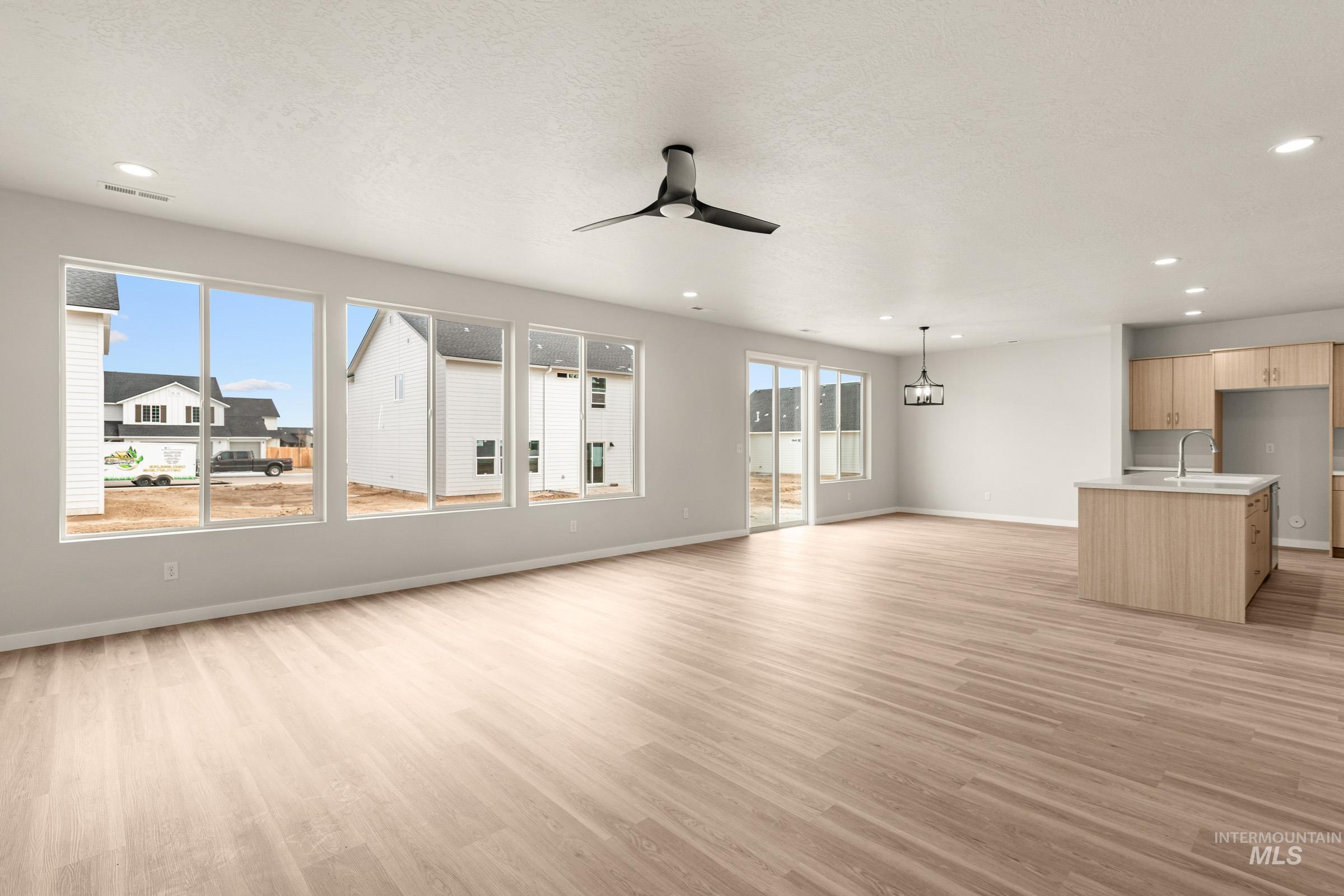13688 Redway Court Caldwell, ID 83607 - Photo 10 of 26 Unfurnished living room featuring light wood-style floors, ceiling fan, recessed lighting, and a textured ceiling