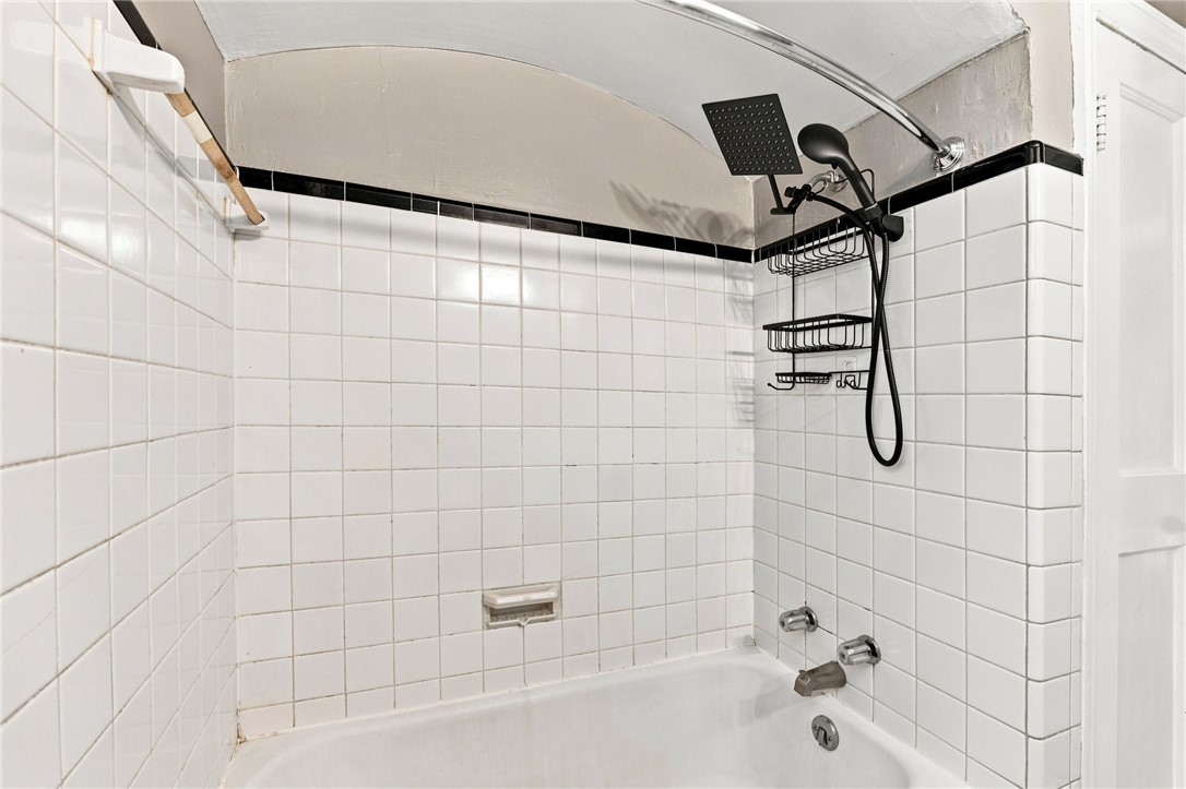 98 Blue Ridge Drive Clemson, SC 29631 - Photo 21 of 32 Classic white tile surrounds a built-in tub with matte black hardware and a curved shower rod.