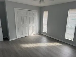 an empty room with wooden floor and windows
