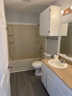 a bathroom with a granite countertop sink toilet a mirror and shower