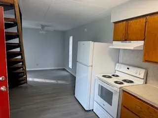 a kitchen with a refrigerator and a stove top oven