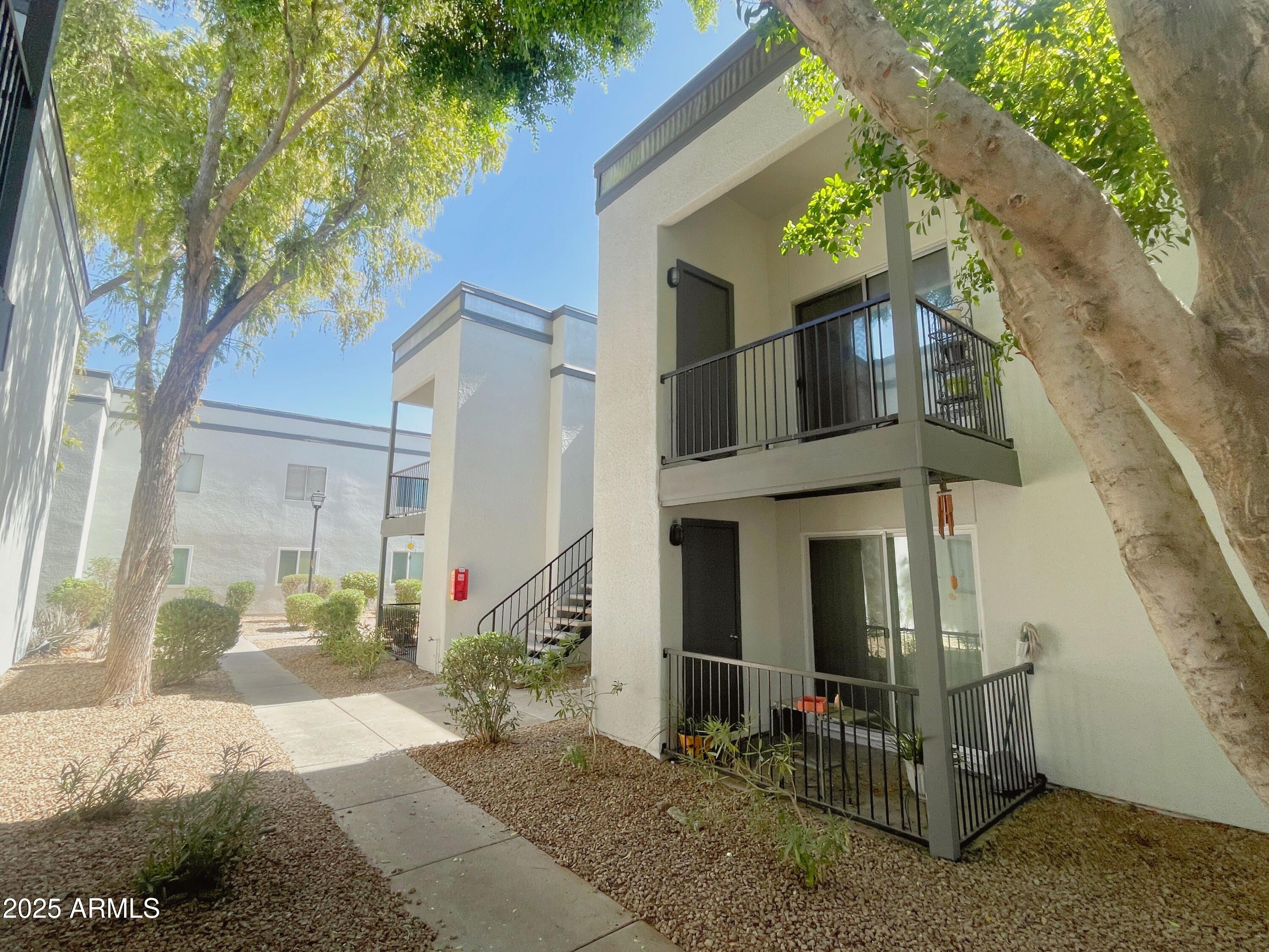 a front view of a house with a tree