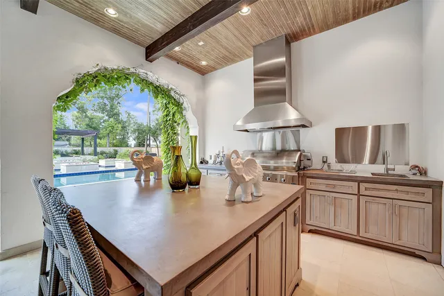 a view of a dining room and livingroom with furniture wooden floor a rug a painting and a chandelier