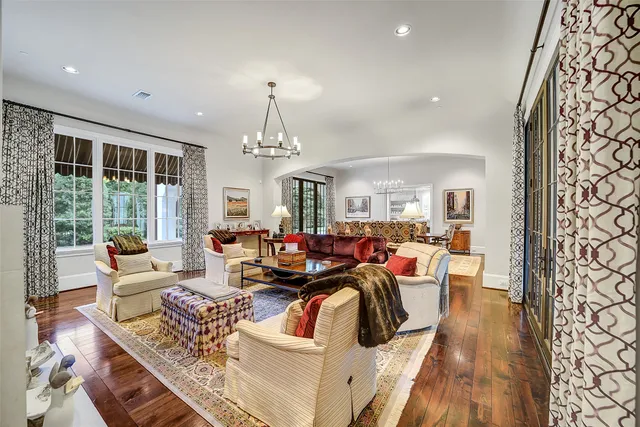a living room with furniture a chandelier and a flat screen tv