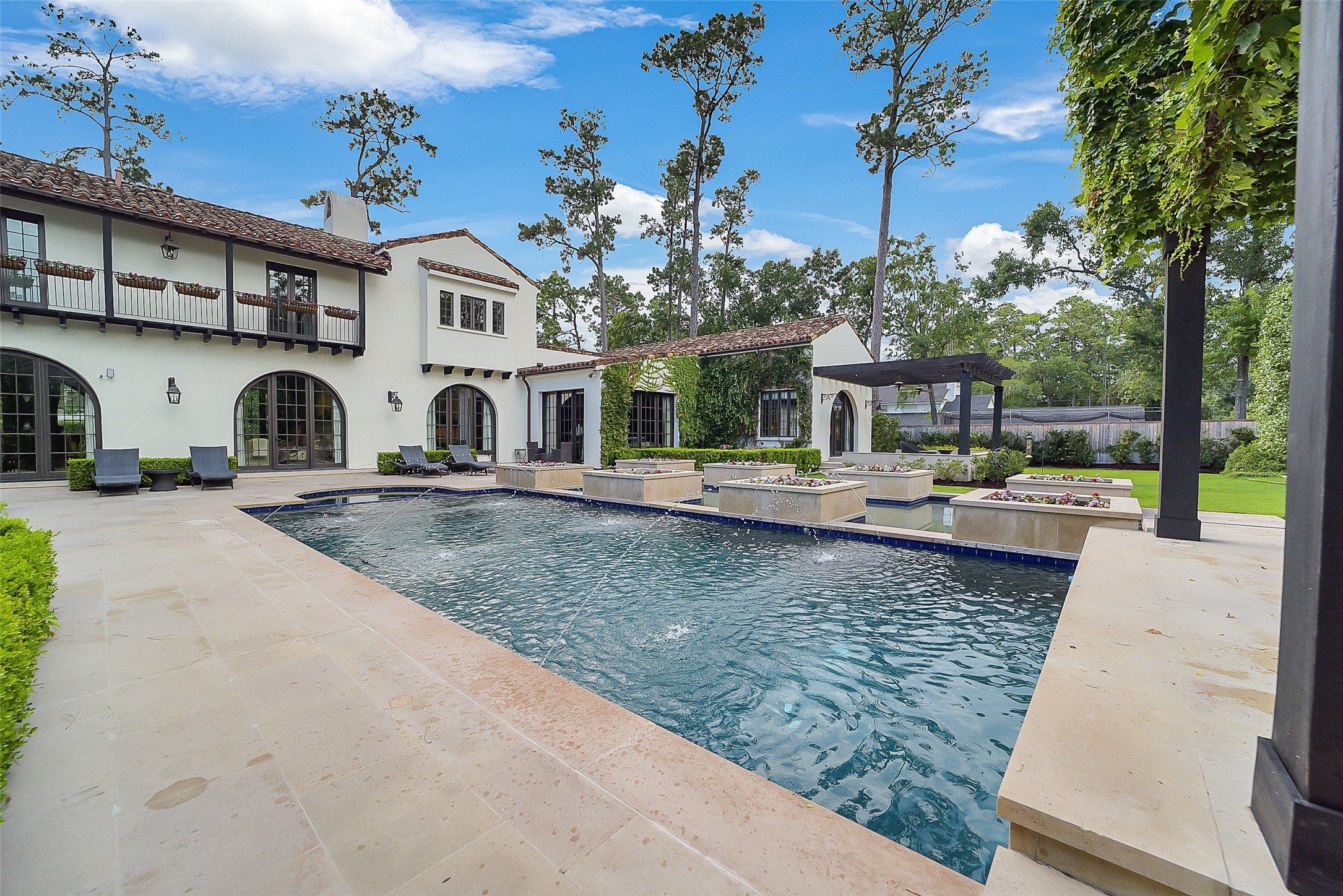 252 Piney Point Road Houston, TX 77024 - Photo 44 of 46 Another view of the pool showcases the elegant fountains adding a touch of visual appeal to the resort-style setting.
