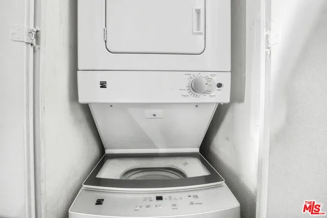 a utility room with stainless steel appliances wooden floor and view living room