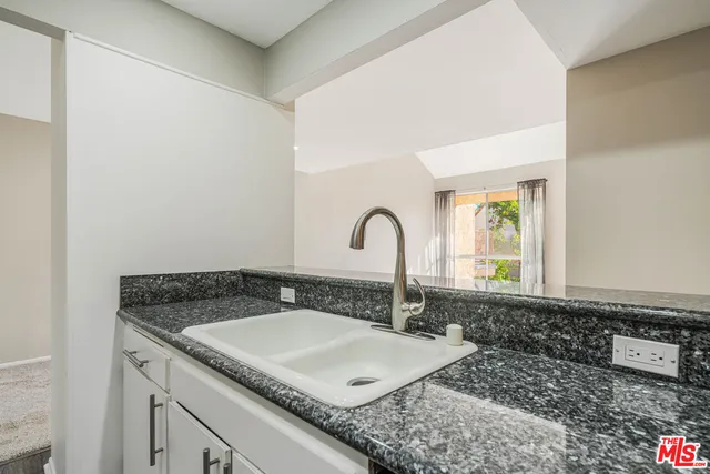 a bathroom with a granite countertop sink and a mirror