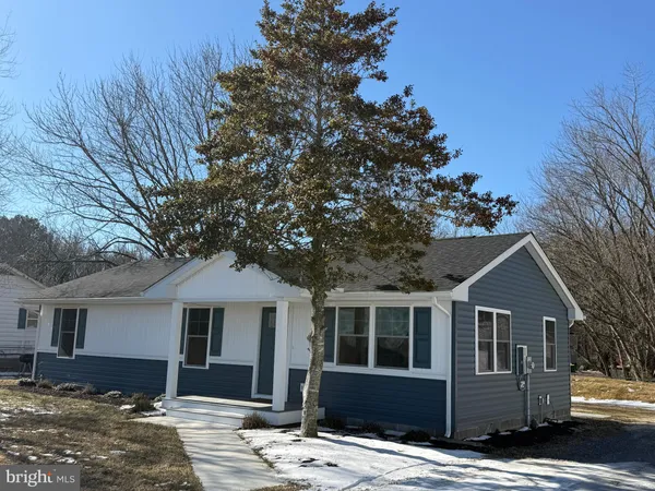 a front view of a house with a tree