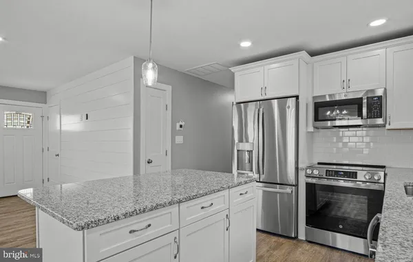 a kitchen with stainless steel appliances granite countertop a refrigerator and a sink