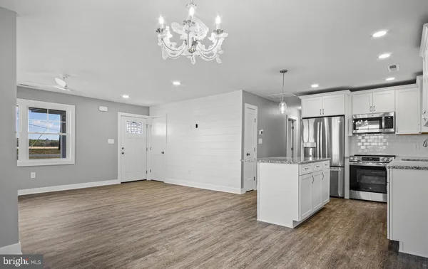 a view of kitchen with stainless steel appliances refrigerator stove top oven and refrigerator