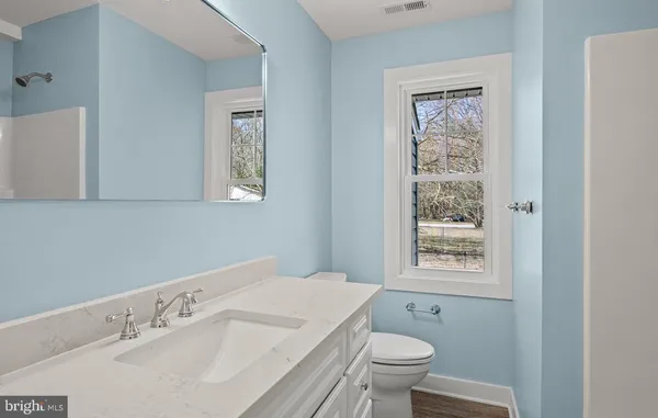 a bathroom with a sink a toilet and a window