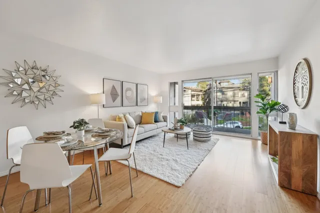a living room with furniture a large window and wooden floor