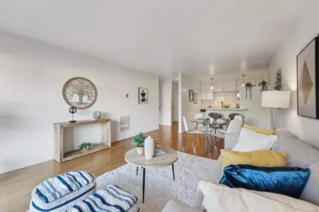 a living room with furniture a clock on wall and a table