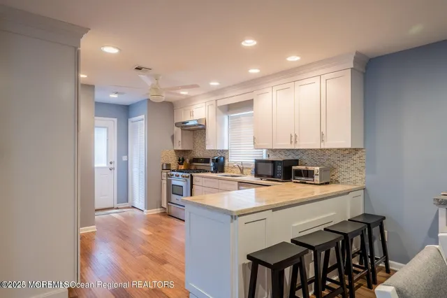 a kitchen with a sink a stove a refrigerator and white cabinets