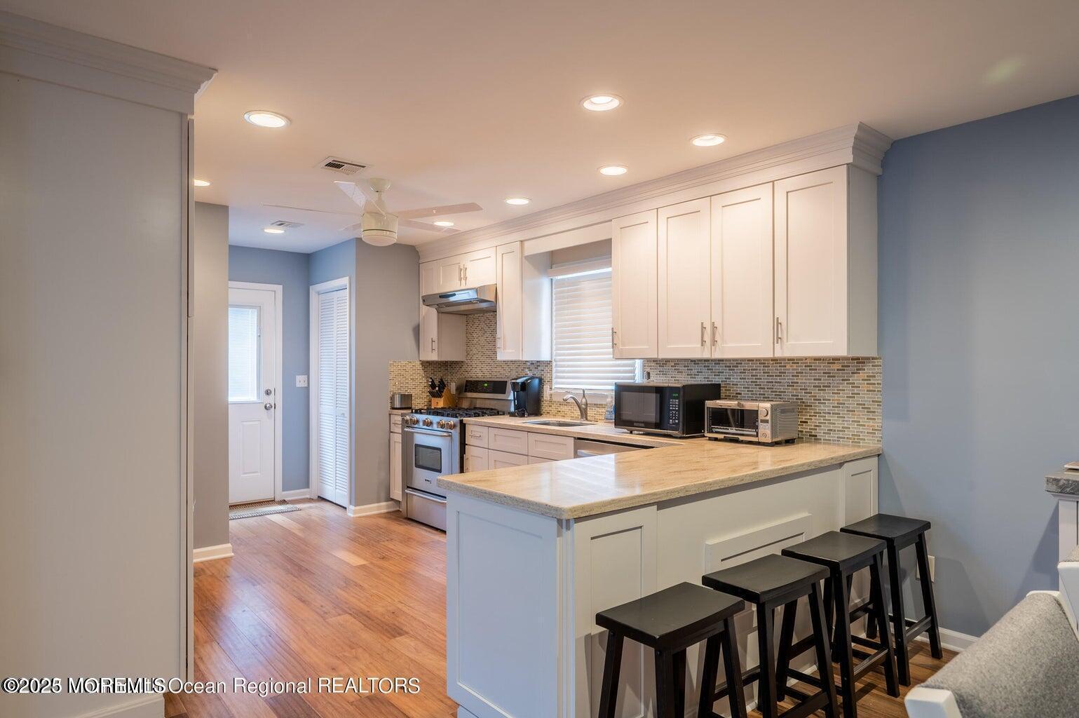 204 Coolidge Avenue Seaside Heights, NJ 08751 - Photo 14 of 22 a kitchen with a sink a stove a refrigerator and white cabinets