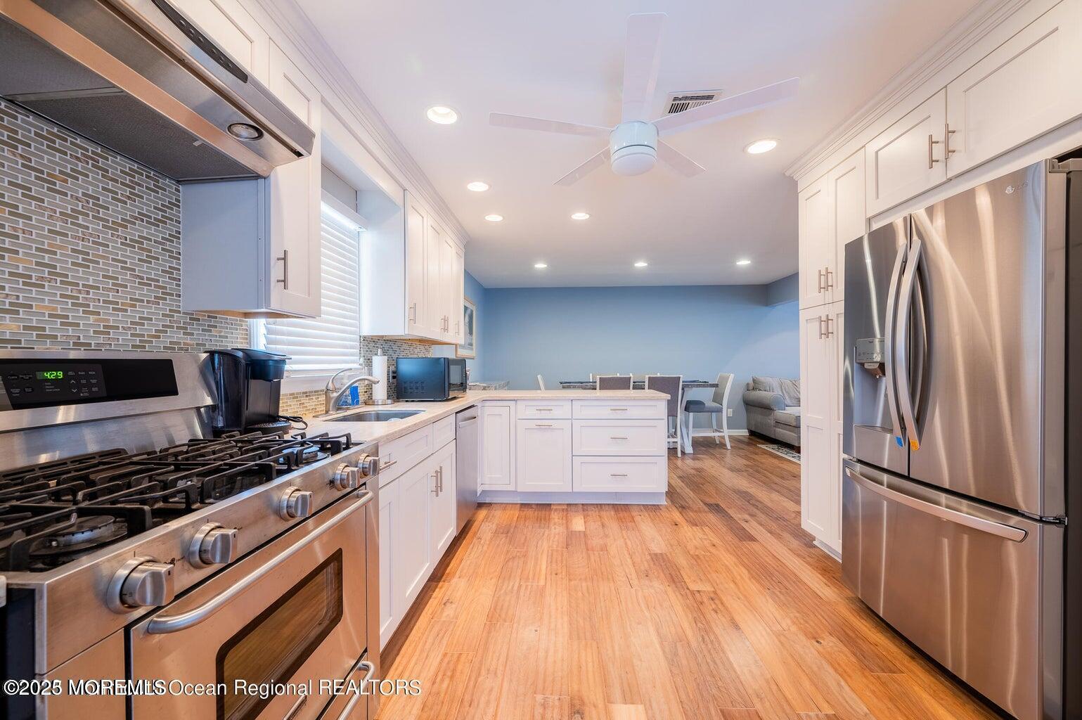 204 Coolidge Avenue Seaside Heights, NJ 08751 - Photo 18 of 22 a kitchen with stainless steel appliances a refrigerator a stove a sink and white cabinets