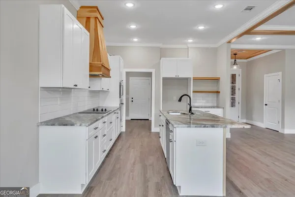 a kitchen with stainless steel appliances granite countertop a stove a sink and a refrigerator