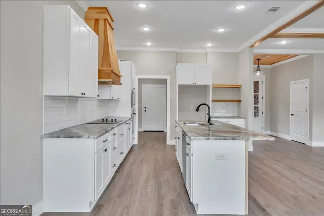 a kitchen with stainless steel appliances granite countertop a stove a sink and a refrigerator
