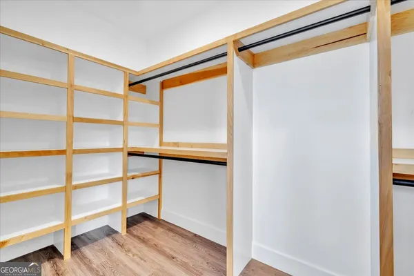 a view of walk in closet with empty racks