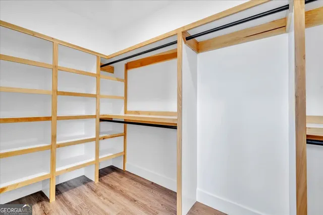 a view of walk in closet with empty racks