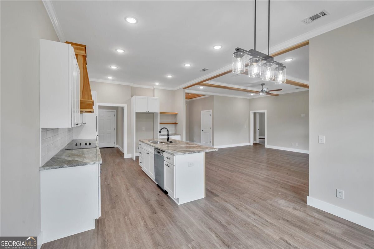87 River Ridge Drive Hawkinsville, GA 31036 - Photo 24 of 65 a large kitchen with kitchen island a stove a sink dishwasher a oven and a dining table with wooden floor