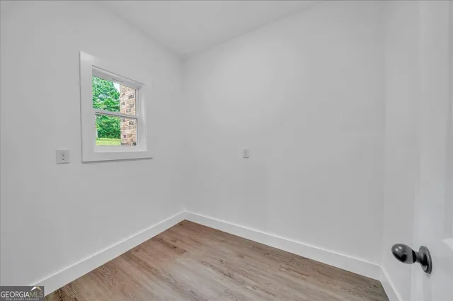 a view of a small space with wooden floor and a window
