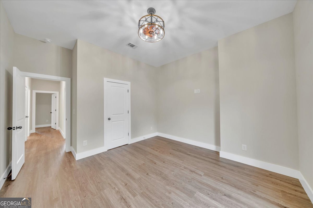 87 River Ridge Drive Hawkinsville, GA 31036 - Photo 56 of 65 an empty room with wooden floor and a ceiling fan