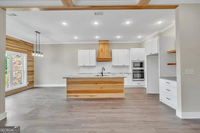 a view of kitchen with stainless steel appliances cabinets and outdoor view