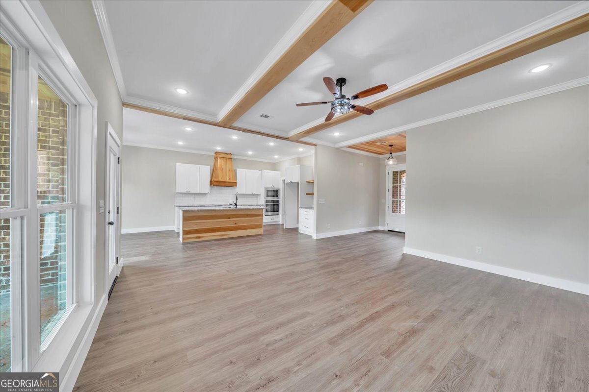 87 River Ridge Drive Hawkinsville, GA 31036 - Photo 10 of 65 en empty room with wooden floor ceiling fan and windows
