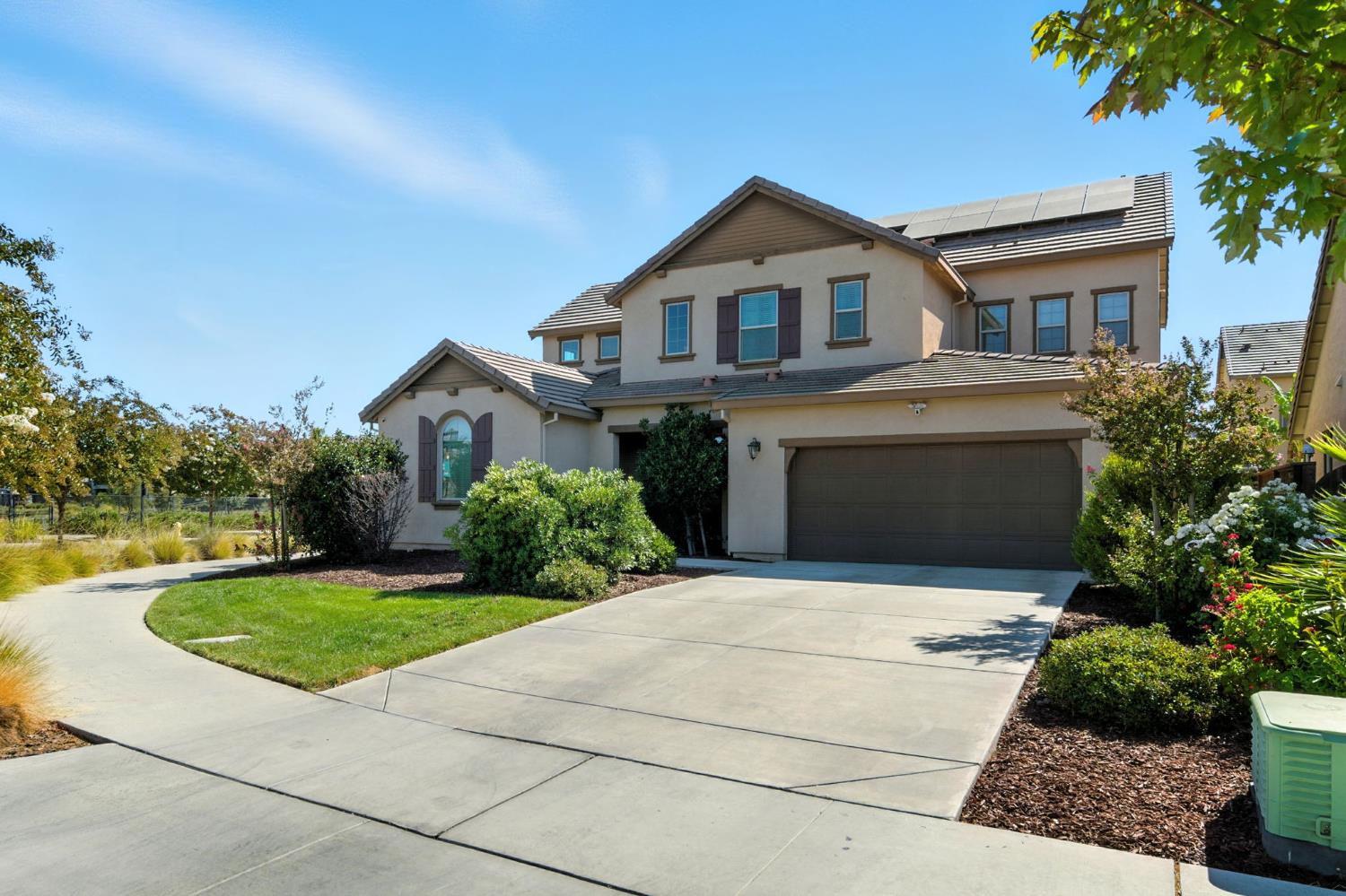 traditional-style house with roof mounted solar panels, concrete driveway, a garage, stucco siding, and a tiled roof