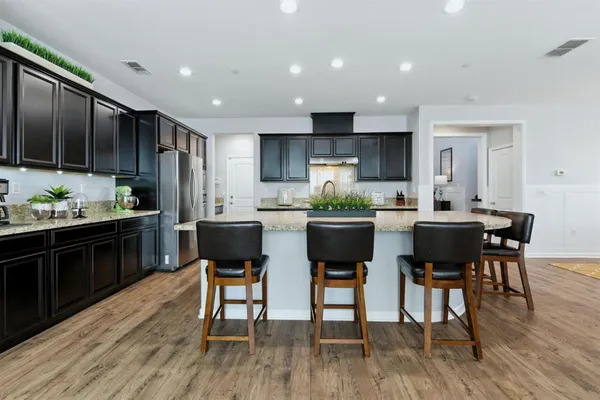 a kitchen with granite countertop wooden floors and chairs